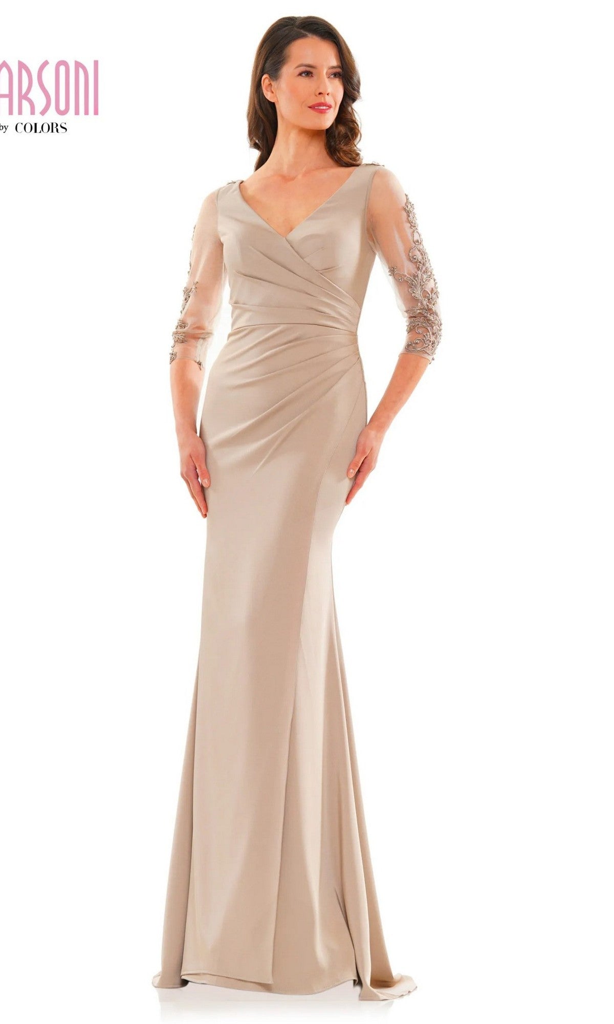 A woman wears the Marsoni MV1146, a long, taupe formal dress with sheer embroidered floral sleeves, standing against a white background.